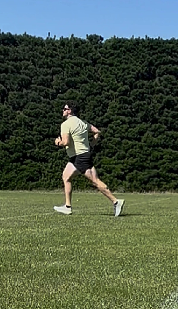 Rory running on a grass field in summer